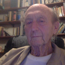 Kurt Kreith sits in front of a bookshelf filled with textbooks.