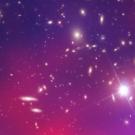 Wide starfield with diffuse red (heat) and blue (density) clouds, scattered stars, and distant galaxies.