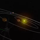 Solar system model with planets orbiting a bright yellow sun against a black background. The solar orbiter circles the periphery in the foreground.
